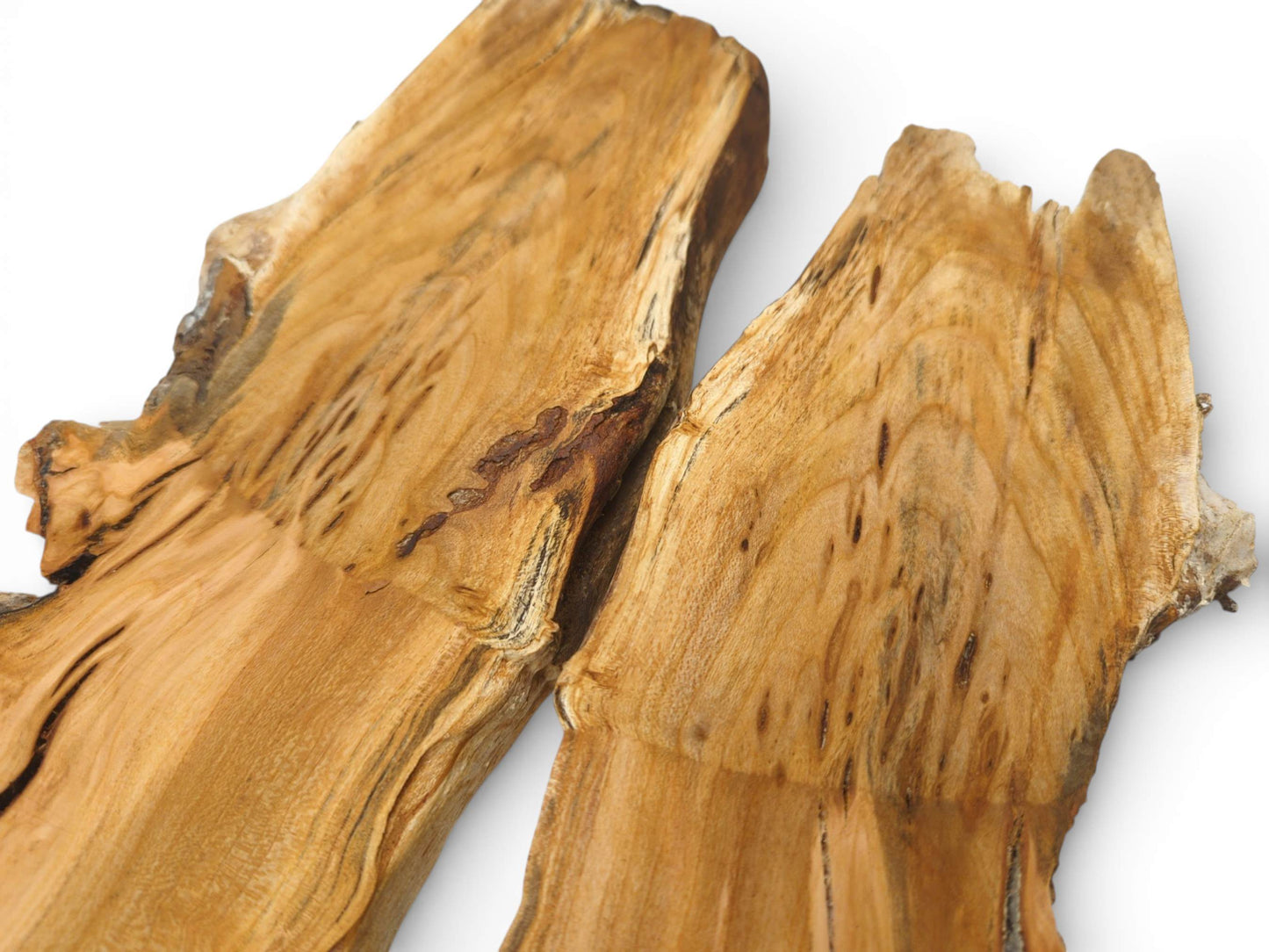 Two irregular sections of cherry root show a golden hue with distinctive dark mineral streaks and figuring.