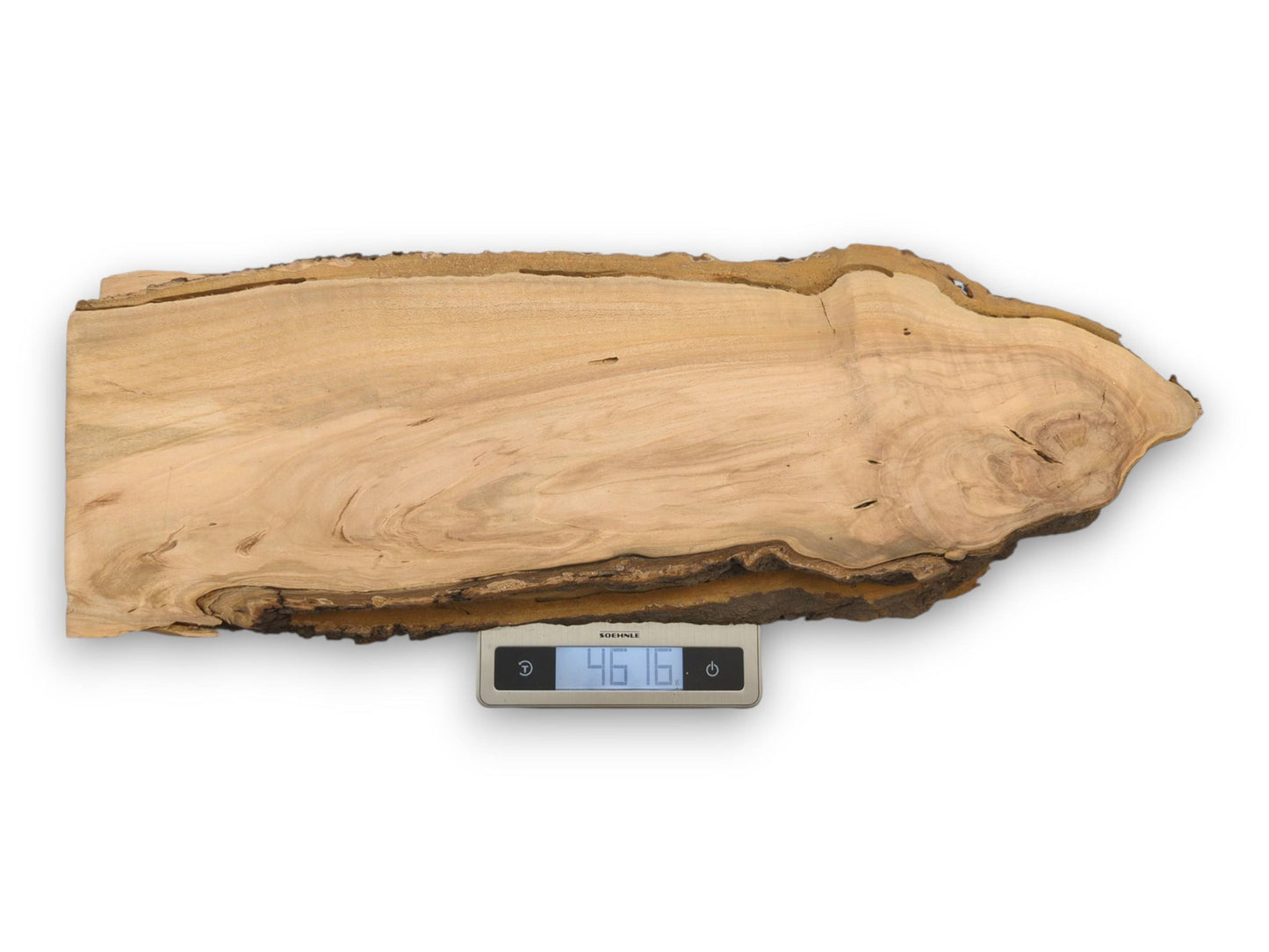A single wild cherry live edge slab resting on a digital scale that reads a measurement of 4616.