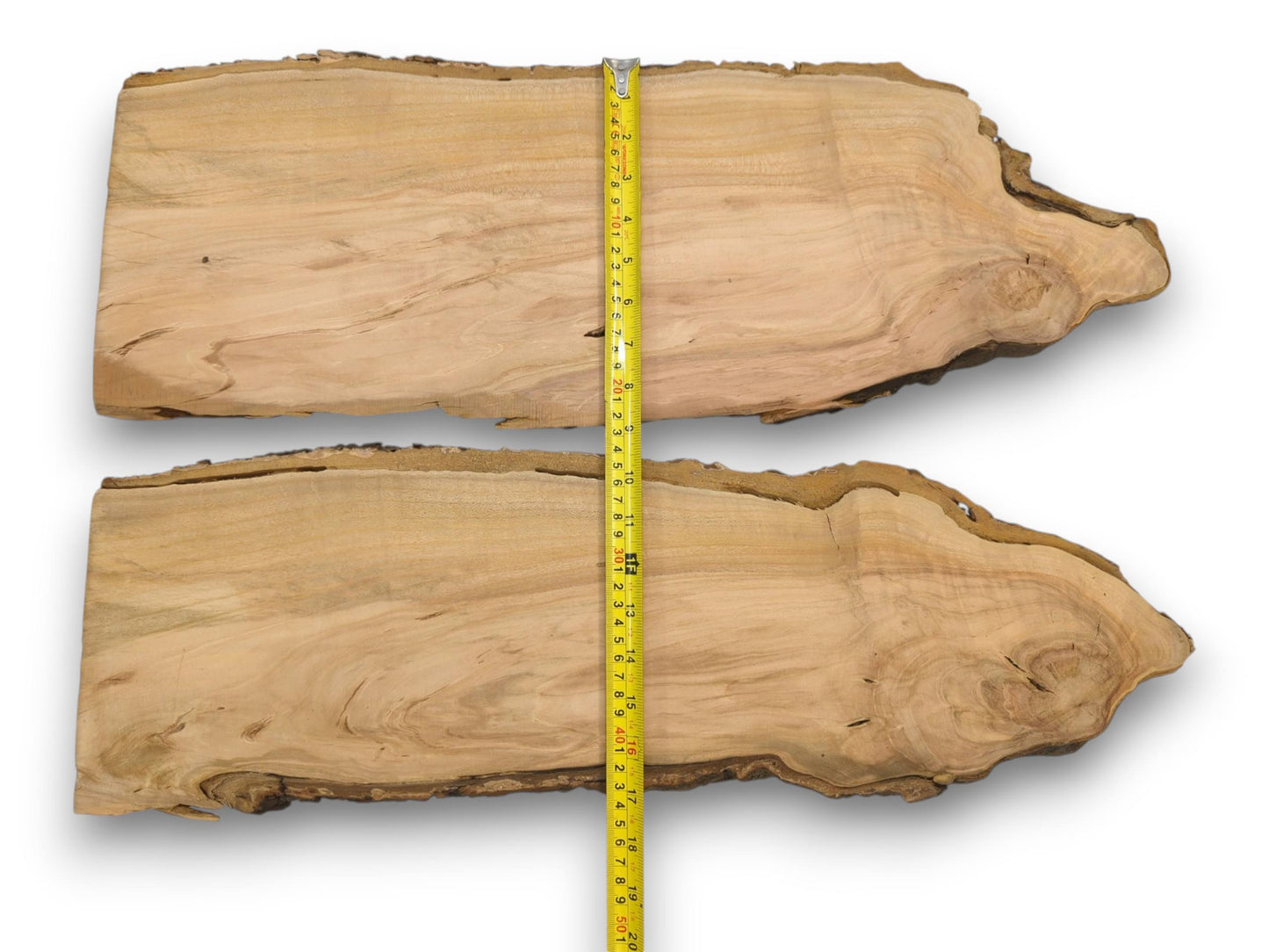 Two live edge wood slabs arranged horizontally with a yellow measuring tape running vertically down the center.