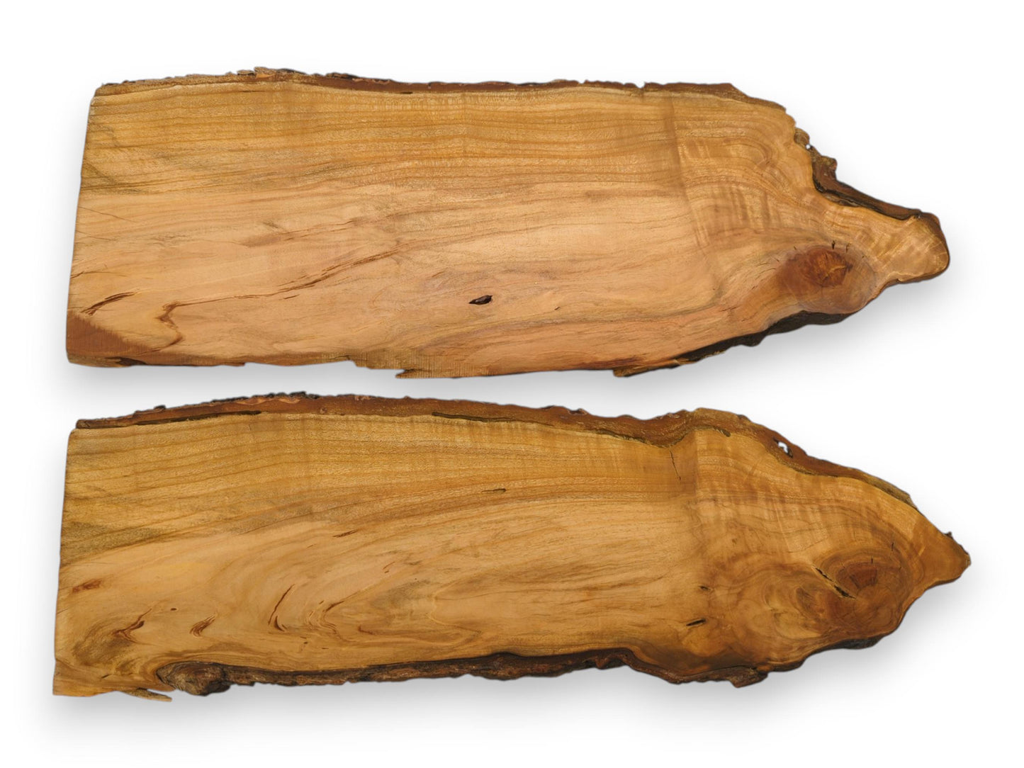 Two horizontal wild cherry wood pieces with irregular bark edges, showcasing their grains and natural shapes.