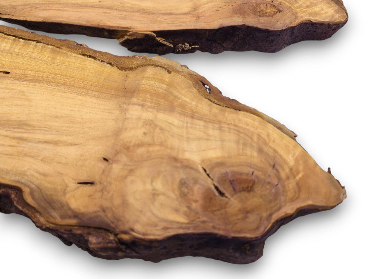 A close-up perspective of two wild cherry wood slabs, showcasing their circular grain and dark edges.