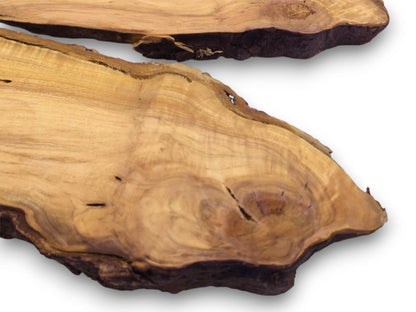 A close-up perspective of two wild cherry wood slabs, showcasing their circular grain and dark edges.