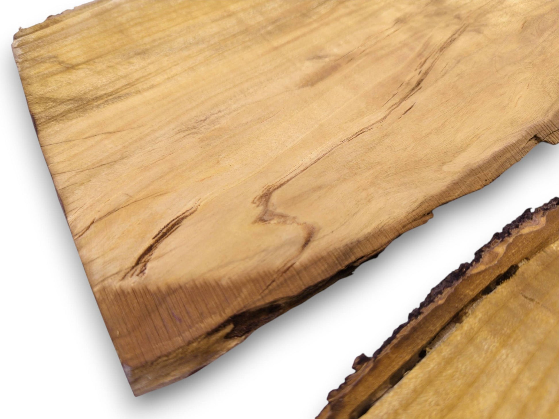 An overhead, diagonal composition of two wild cherry slabs, detailing their linear grain and bark-covered edges.