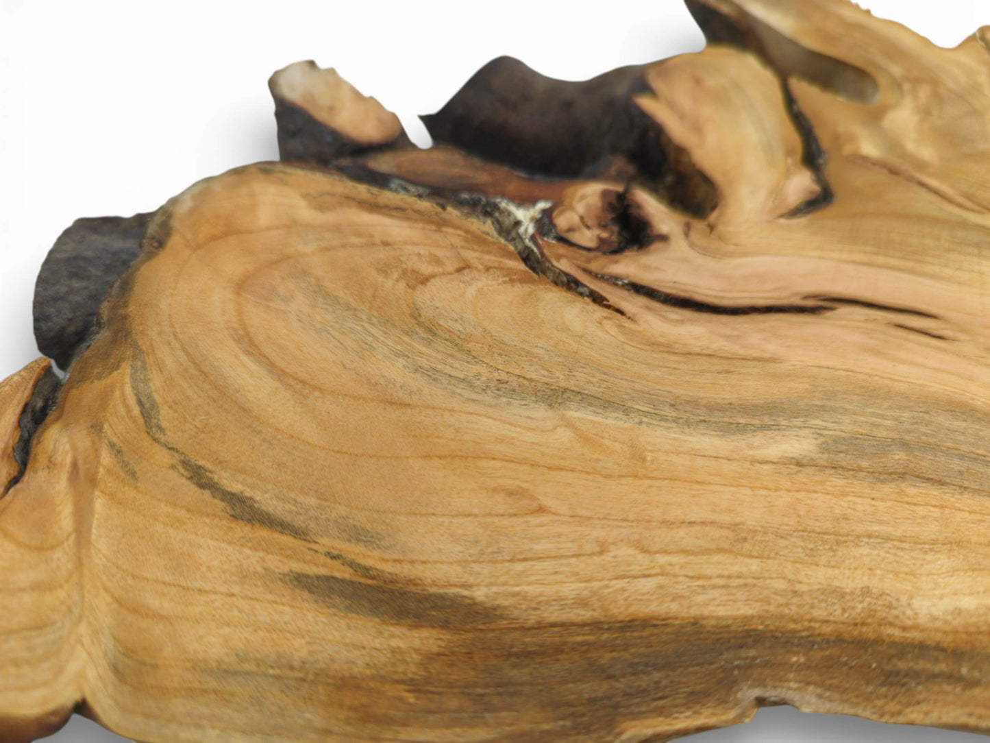 A close-up shot capturing the undulating grain and darker striations on the smooth wood slab.