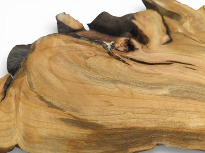 A close-up shot capturing the undulating grain and darker striations on the smooth wood slab.