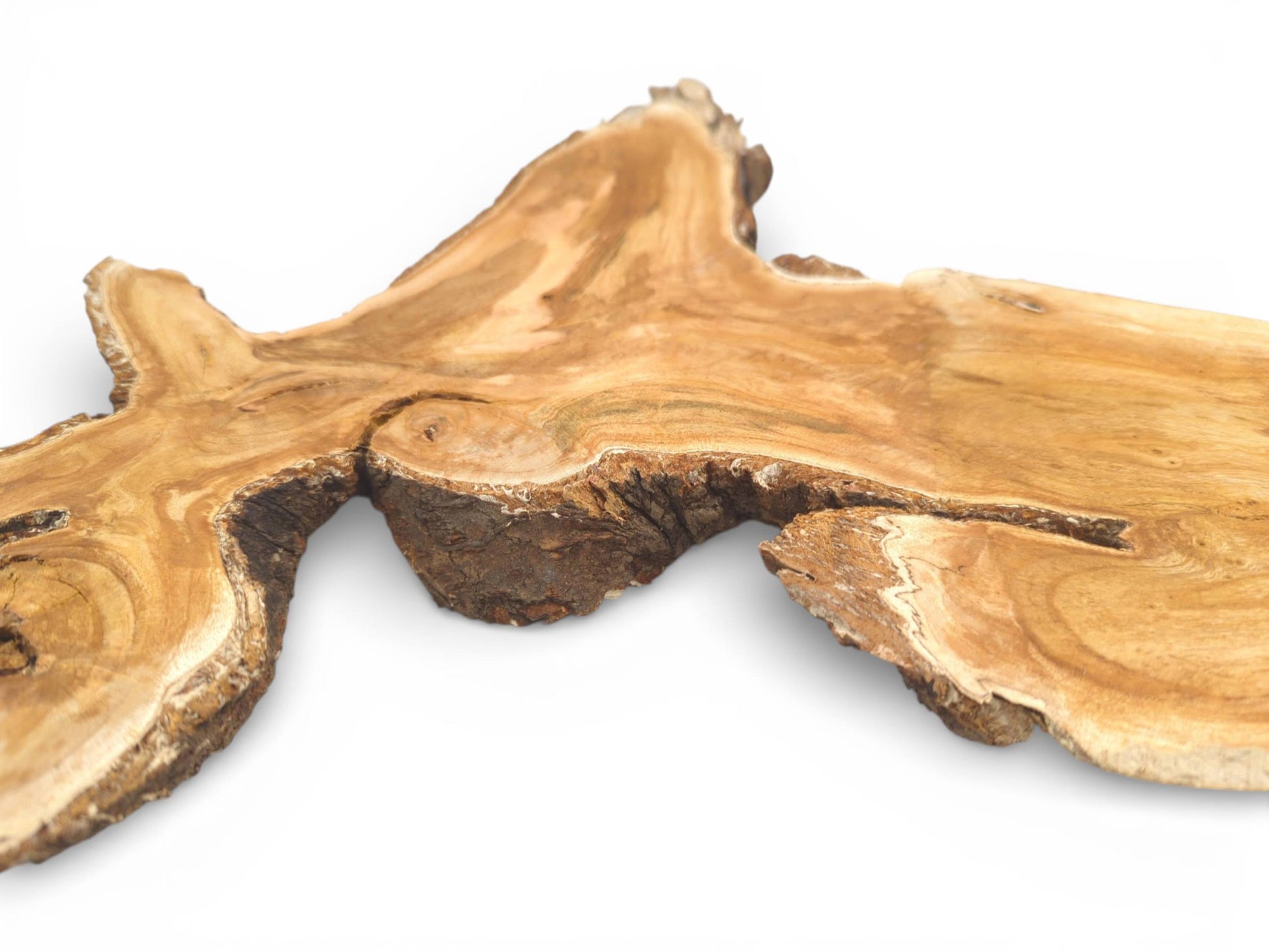 A low-angle perspective across a wild cherry slab, emphasizing its thick, textured live edge and woodgrain.