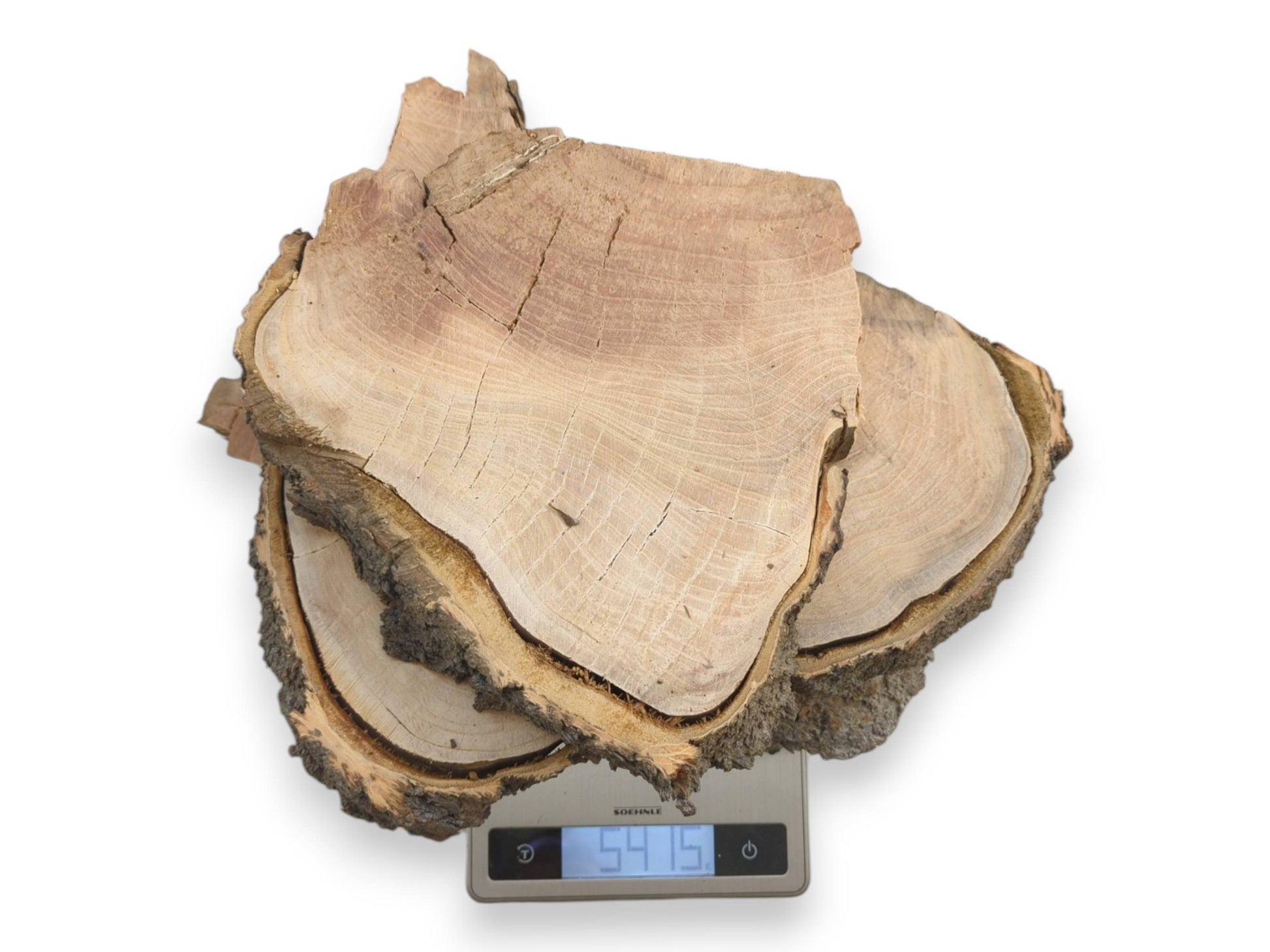 An overhead view shows stacked, raw-edged timber pieces being weighed on a digital scale.