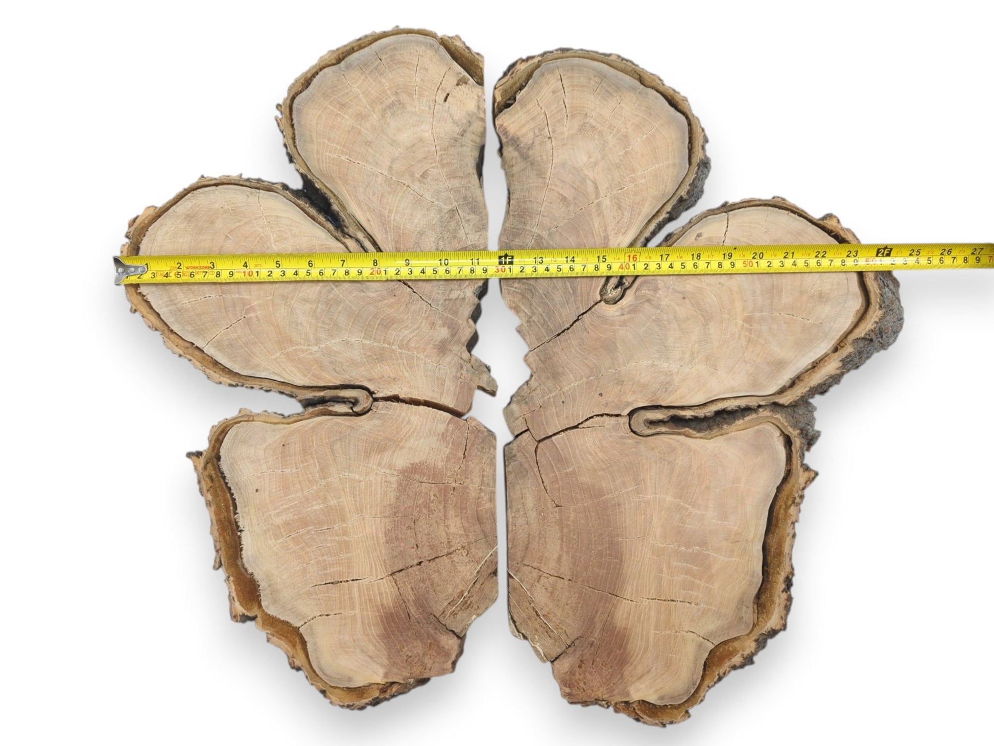 A yellow measuring tape spans six fractured lumber pieces arranged in a clover pattern.