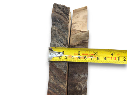 Two cherry wood slabs with natural bark edges, measured by a yellow tape on white background.