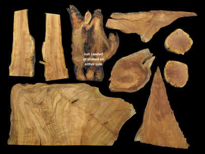 Nine varied cherry wood pieces with live edges, some planed and sanded, on a black background.