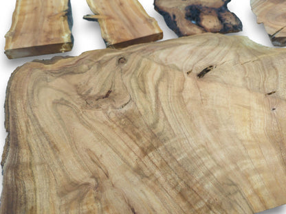 Close-up of a large, light-colored cherry wood slice with visible grain and a knot.