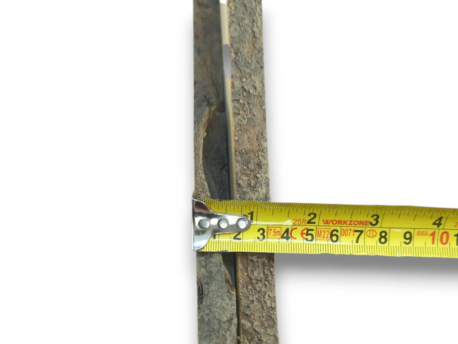 A yellow tape measure against a thin, rough-barked cherry wood piece on a white background.