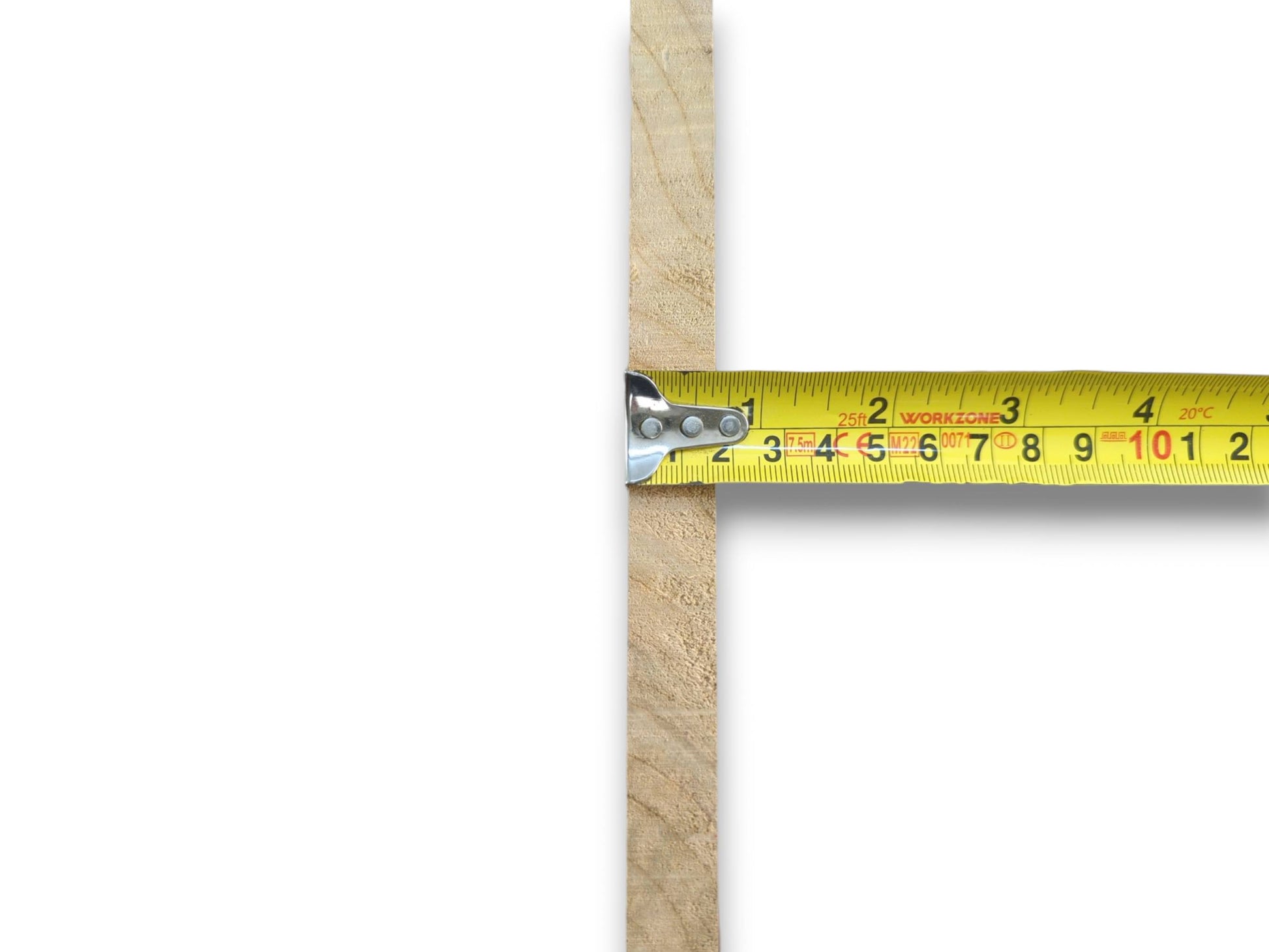 A yellow tape measure against a thin, light-colored wood piece with a rough edge.