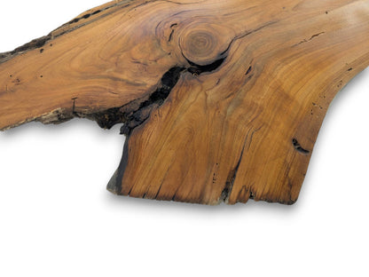 A close-up of a live edge wood slab with a prominent knot and dark cracks.