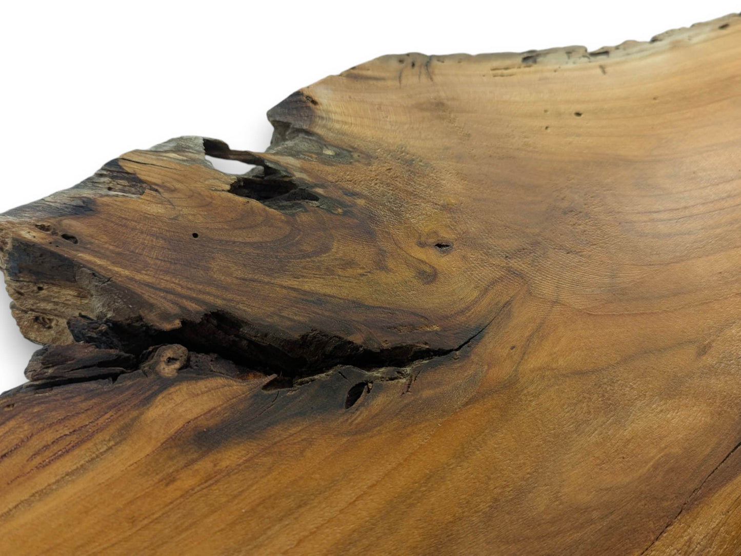 A close-up of a cherry wood slab with a natural live edge and dark cracks.