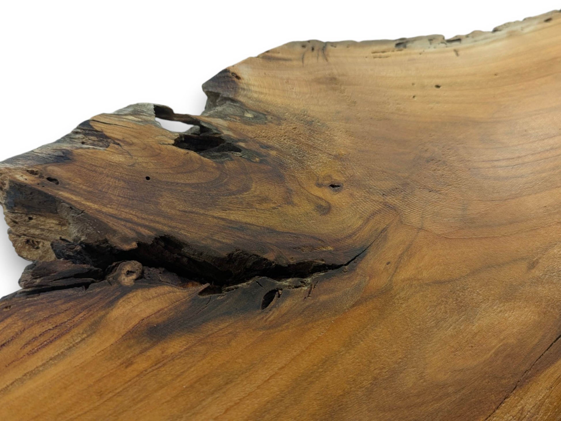 A close-up of a cherry wood slab with a natural live edge and dark cracks.