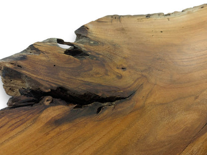 A close-up of a cherry wood slab with a natural live edge and dark cracks.
