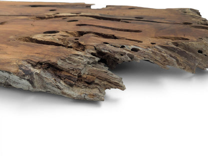 A close-up, low-angle view of a cherry wood slab with a natural live edge.