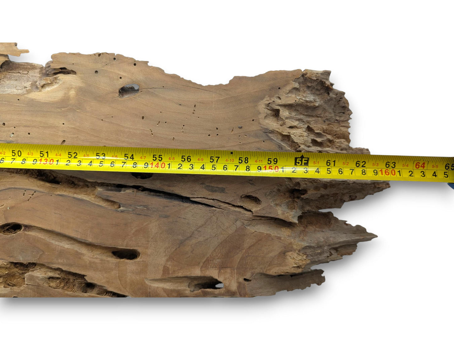 A long, light brown cherry wood slab with a live edge and a measuring tape.