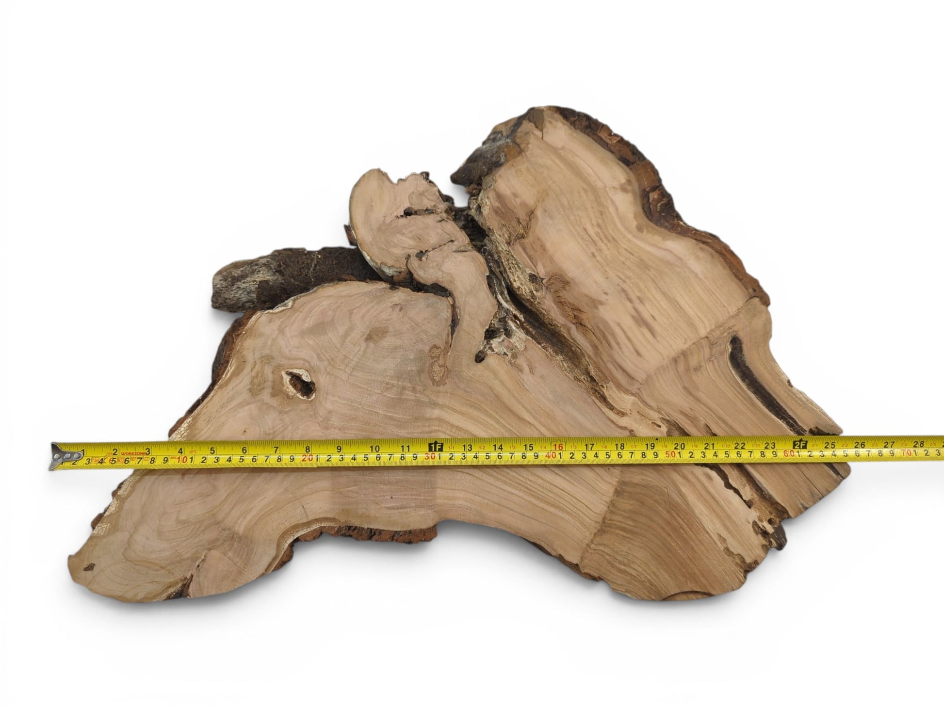 A light brown wild cherry wood slab with a live edge and a measuring tape.