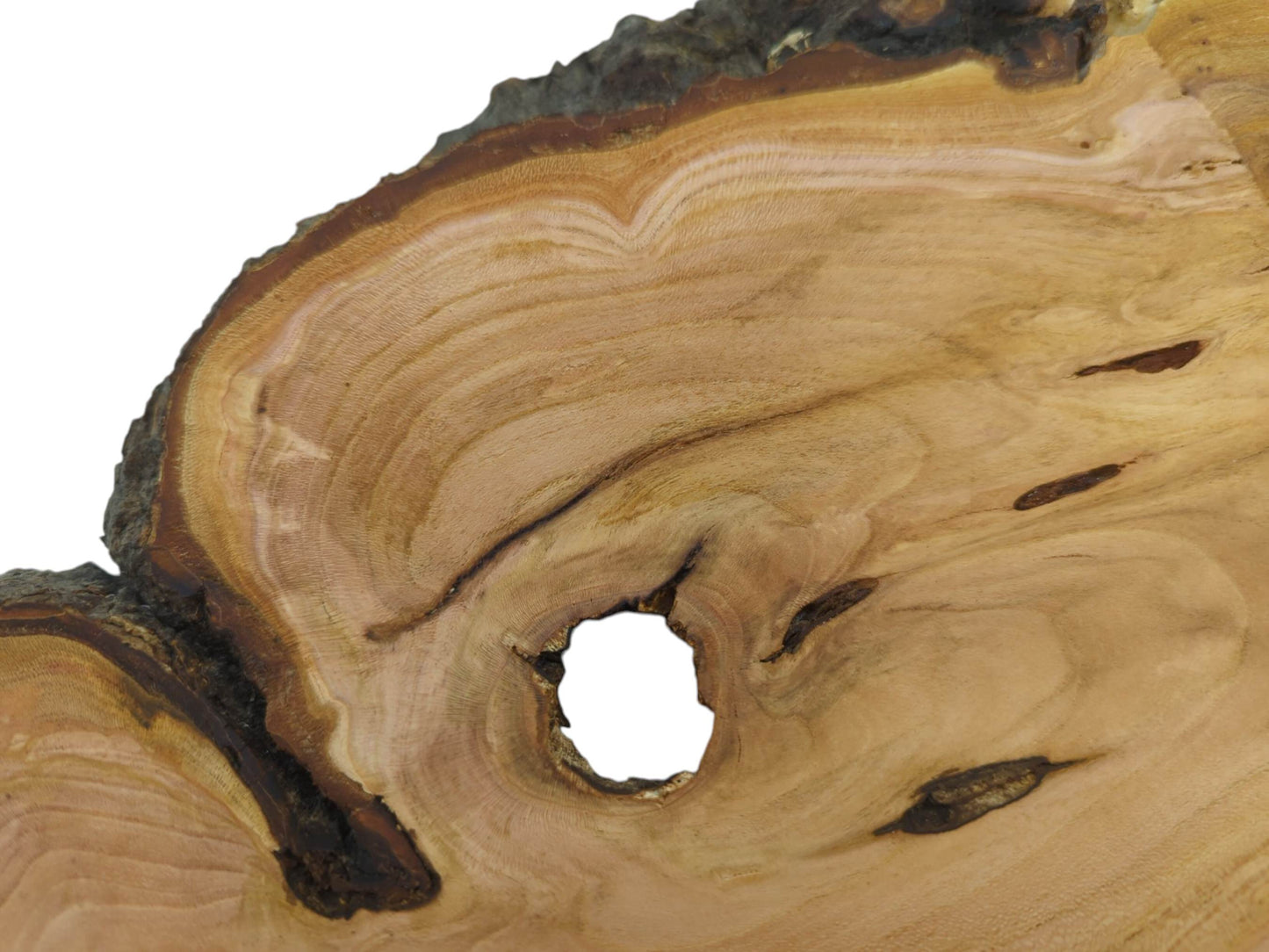Close-up of a wild cherry wood slab with a large central hole and natural grain.