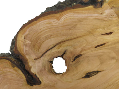 Close-up of a wild cherry wood slab with a large central hole and natural grain.