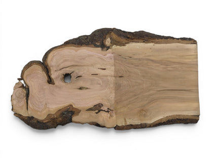 A light brown wild cherry wood slab with a live edge and a natural hole.