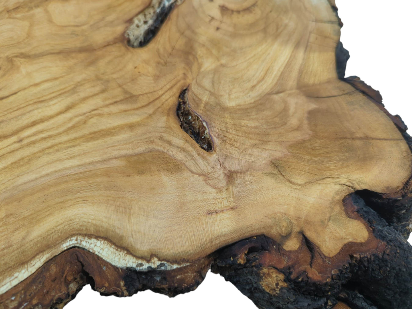 Close-up of a wild cherry wood slab with natural grain, knots, and dark live edges.