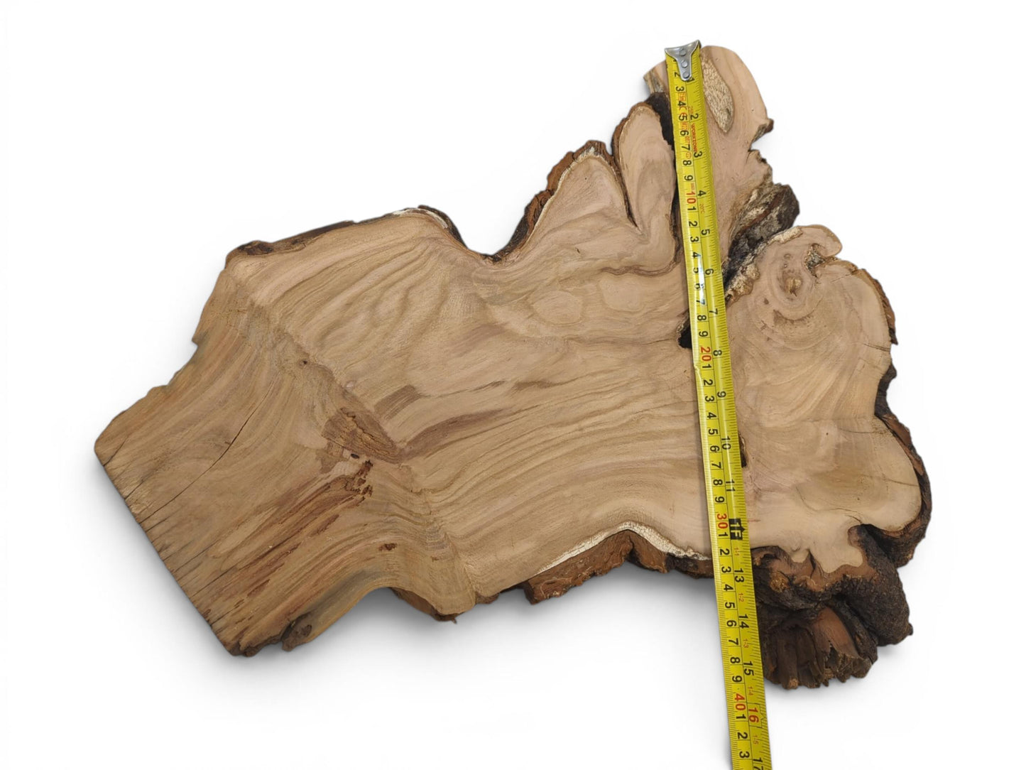 An irregularly shaped wild cherry wood slab with a measuring tape on a white background.