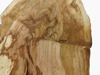 A close-up of a light brown cherry wood slab with a live edge and visible grain.