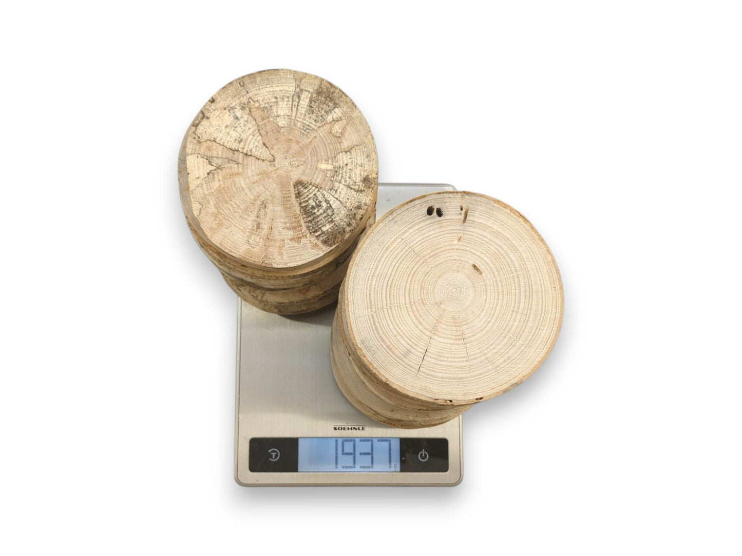 Two stacks of timber discs with contrasting weathered and clean surfaces on a digital scale.