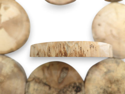 A central timber plank's edge shows vertical grain and dark markings against blurred rounds.
