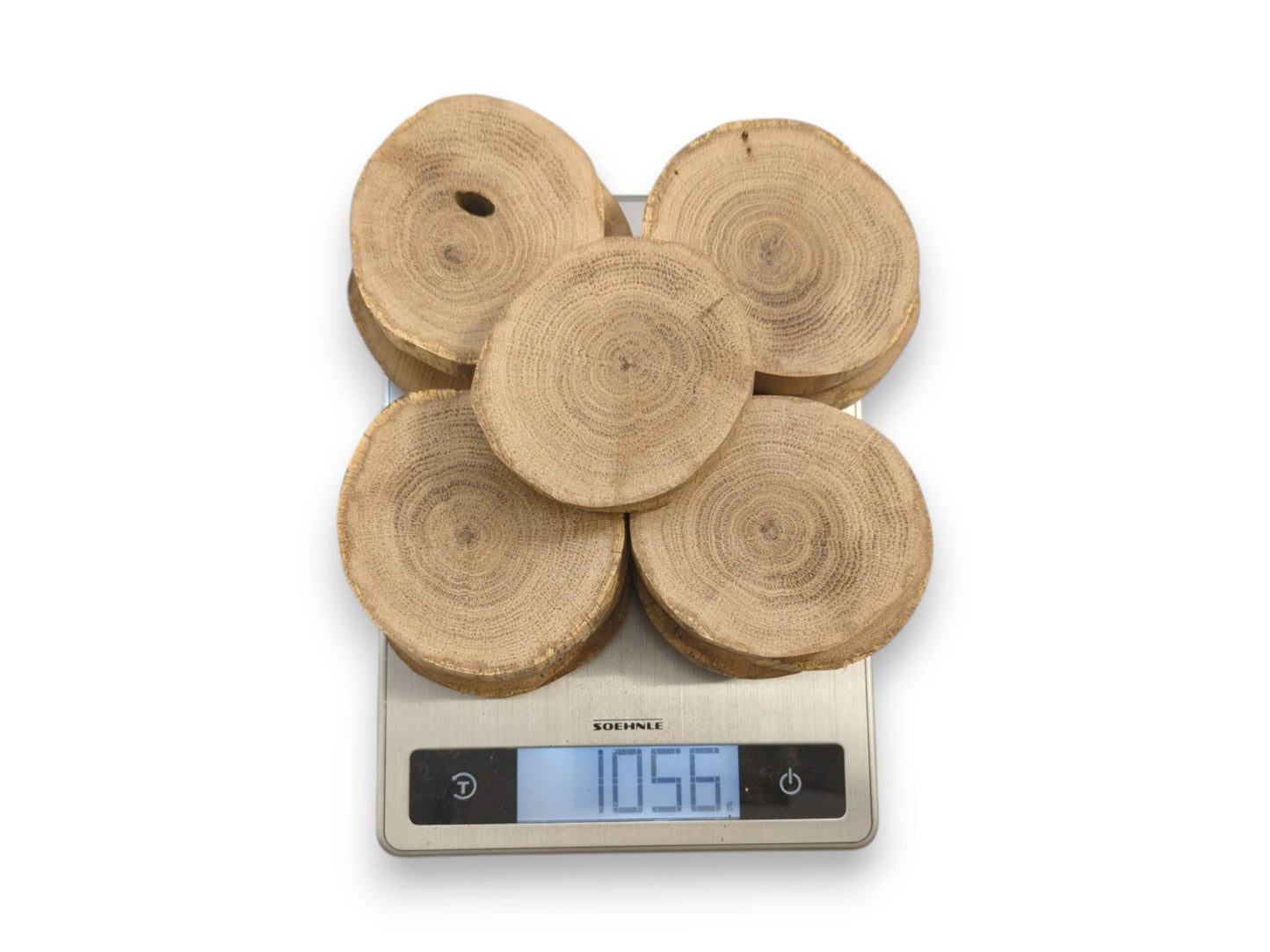 Five circular oak cross-sections with visible grain are weighed on a digital scale reading 1056.