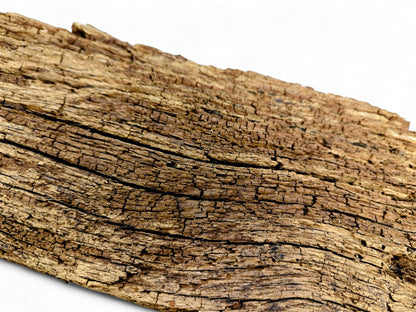 Weathered, dry, brown reclaimed wood fragment displaying deep cracks and a crumbly, flaking surface.