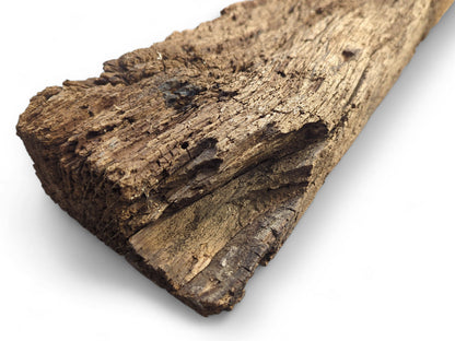 Time-worn, dark brown reclaimed wood beam fragment showing a deeply cracked, flaking, and crumbly surface.