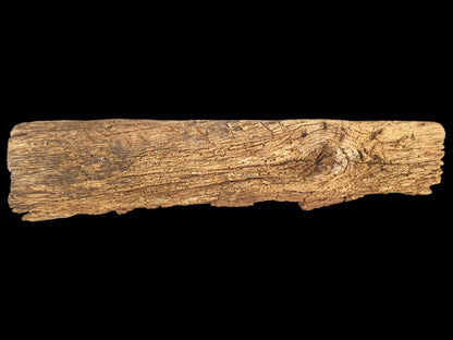 Rough, tan reclaimed wood beam segment, displaying distinct grain, a gnarled knot, and peeling brittle texture.