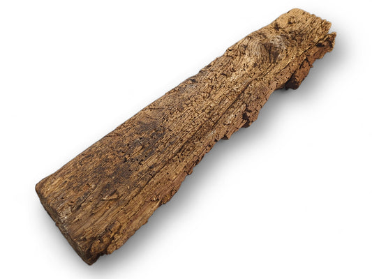 A dark brown, aged reclaimed wood beam fragment, exhibiting a deeply weathered, flaking, and crumbly texture.
