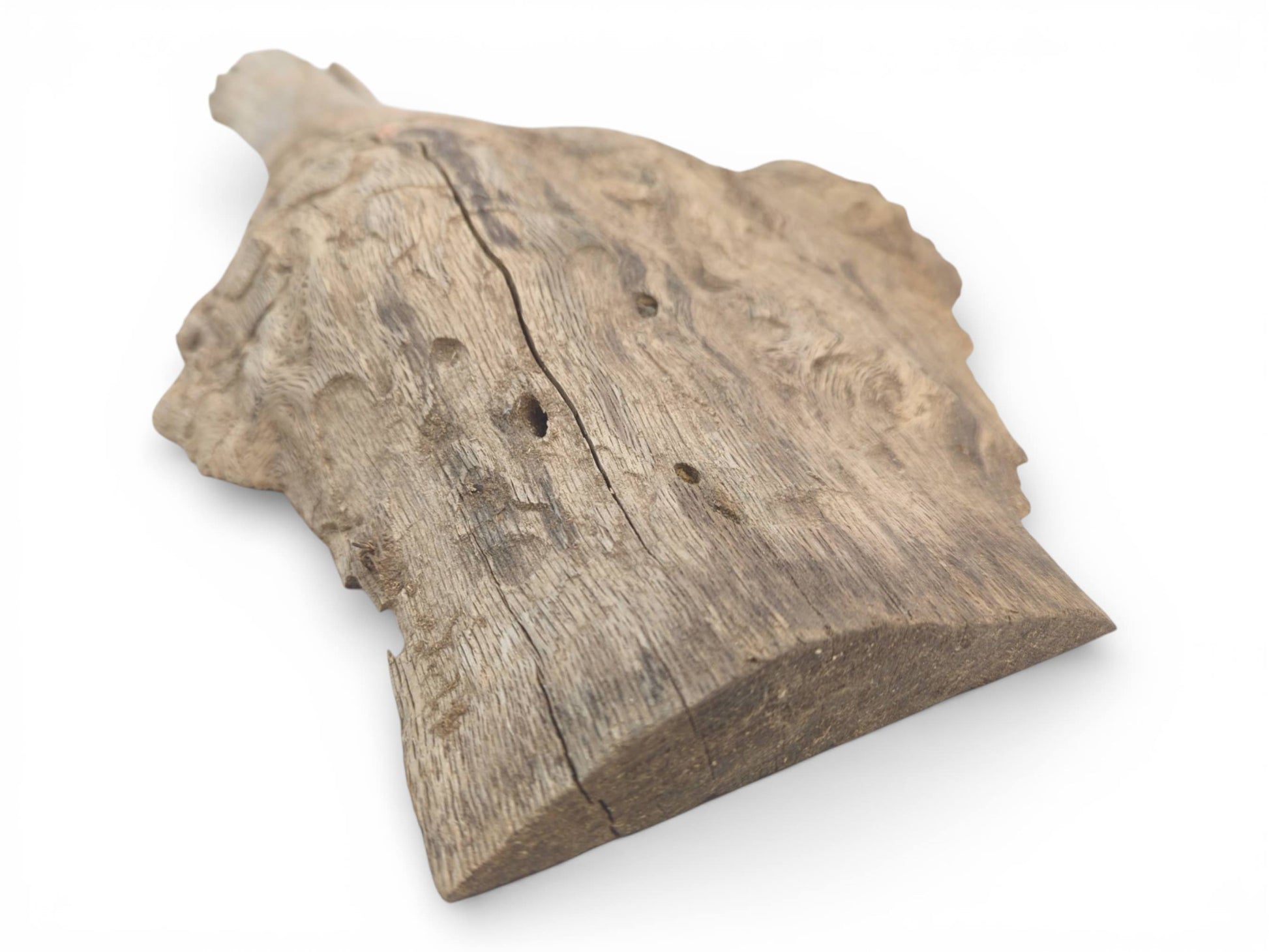 Angled perspective of a raw, weathered oak piece showing its coarse texture, a central split, and thickness.