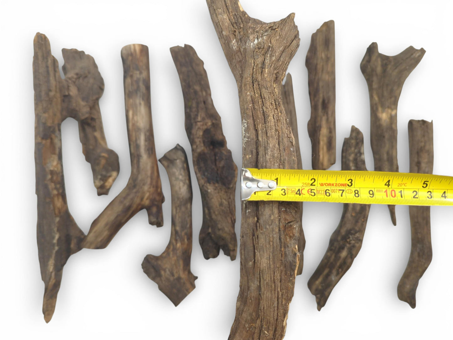 A top view of various weathered timber pieces, a tape measure showing dimensions in multiple units.