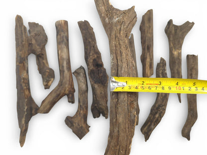 A top view of various weathered timber pieces, a tape measure showing dimensions in multiple units.