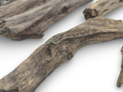 An assortment of bare, weathered wood pieces is arranged to showcase their grain patterns and knots.