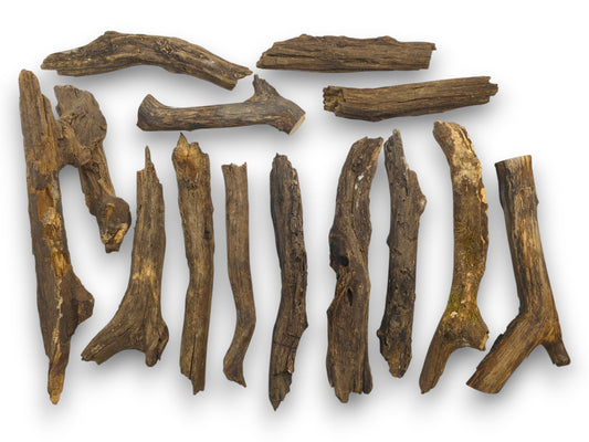 An overhead view of an assortment of weathered, barkless brown wood sticks in various natural shapes.