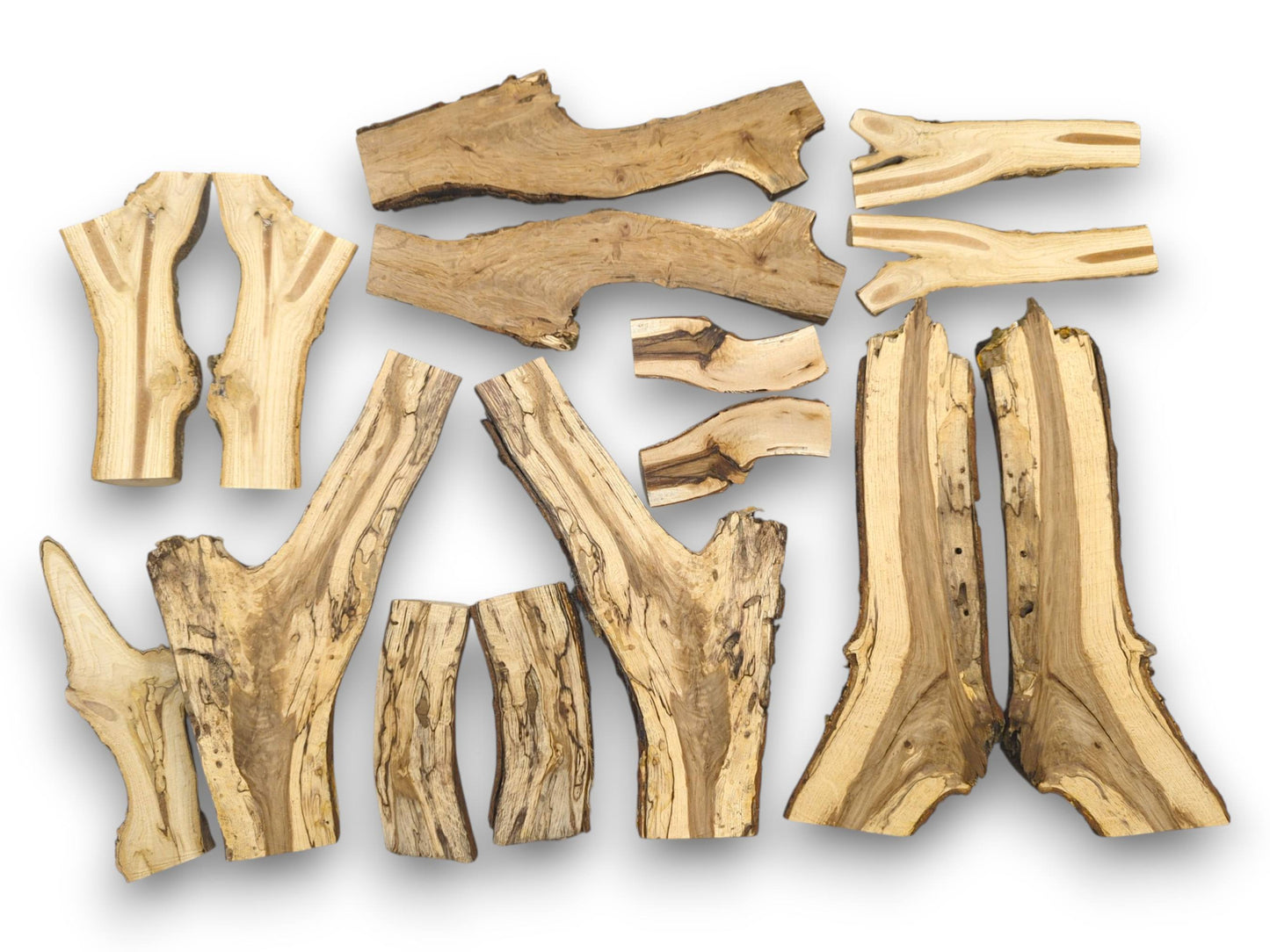A flat-lay assortment of split wood branch halves displaying diverse shapes, live edges, and striped grains.