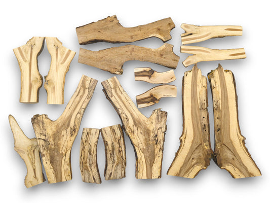 A flat-lay assortment of split wood branch halves displaying diverse shapes, live edges, and striped grains.