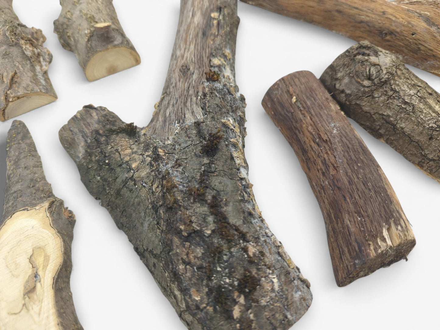 A scattered collection of halved tree branches shows both rough bark exteriors and smooth, cut sides.