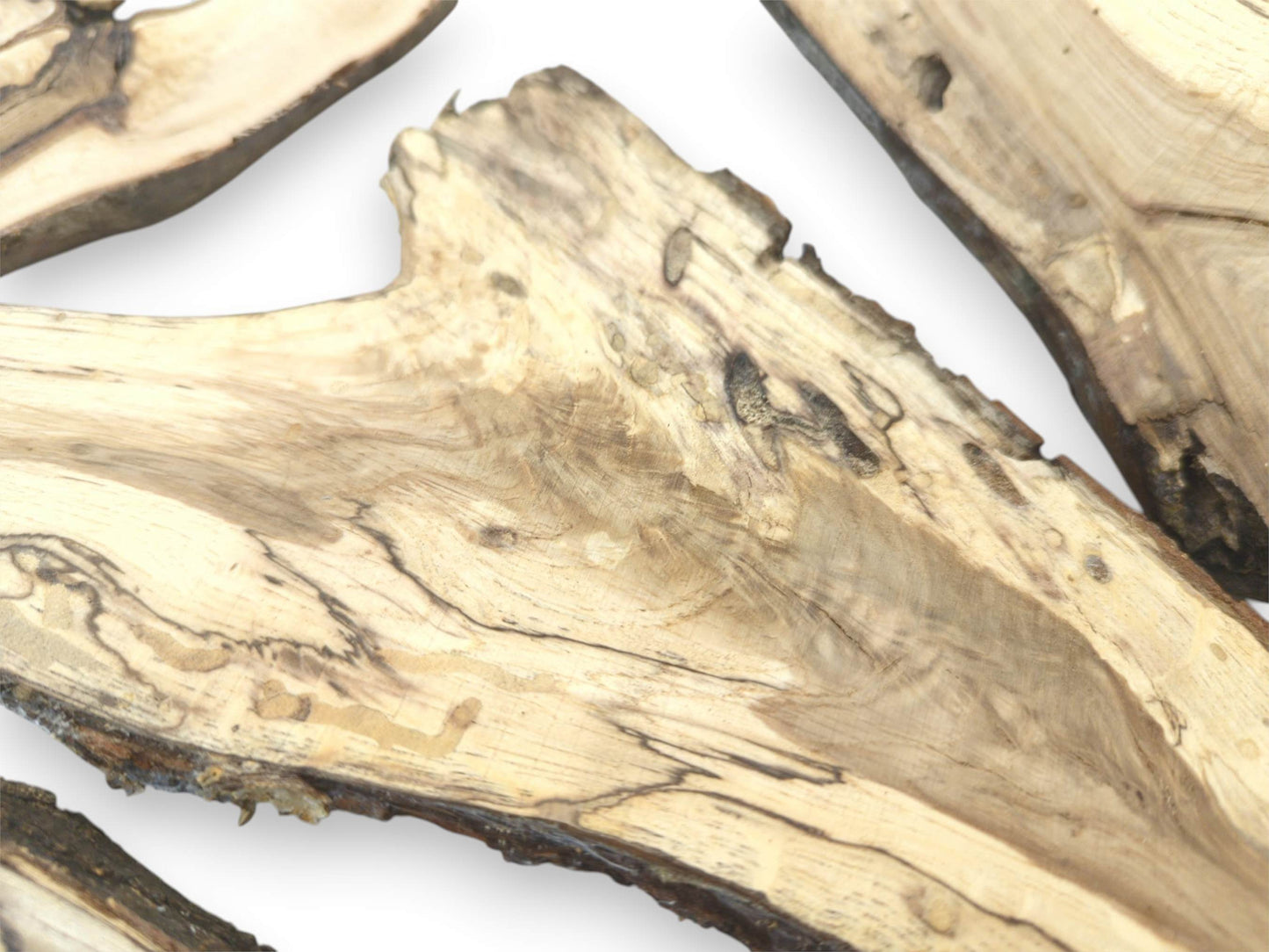 A detailed close-up of a split branch half, revealing its light wood and dark, marbled grain.