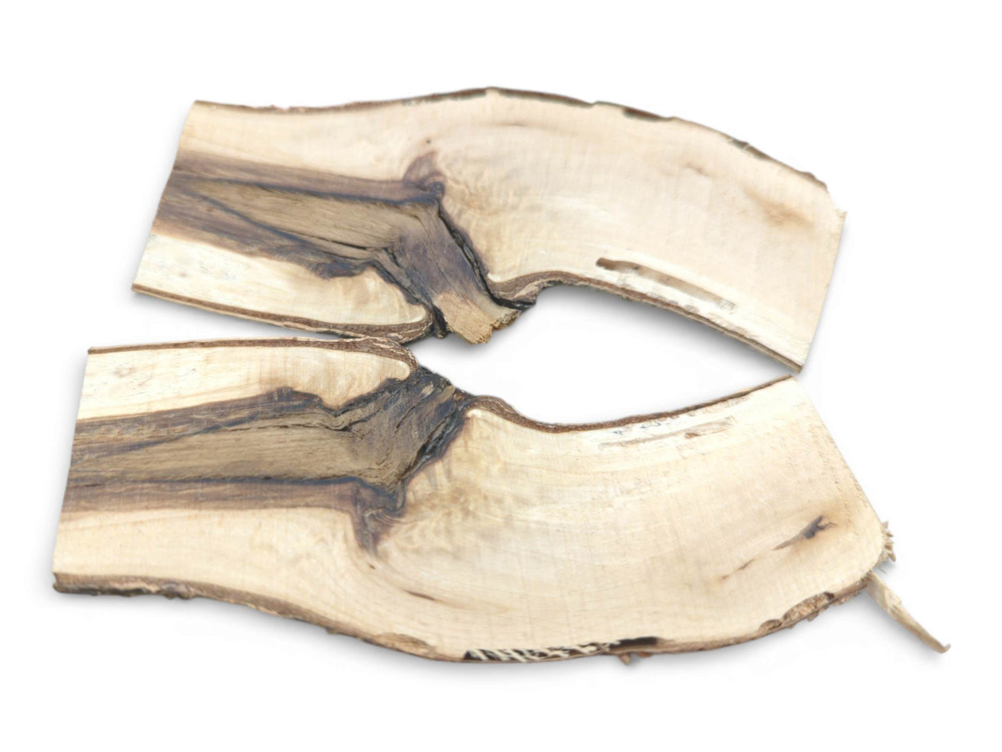Two wood branch halves laid flat, revealing a prominent dark streak through the light interior grain.