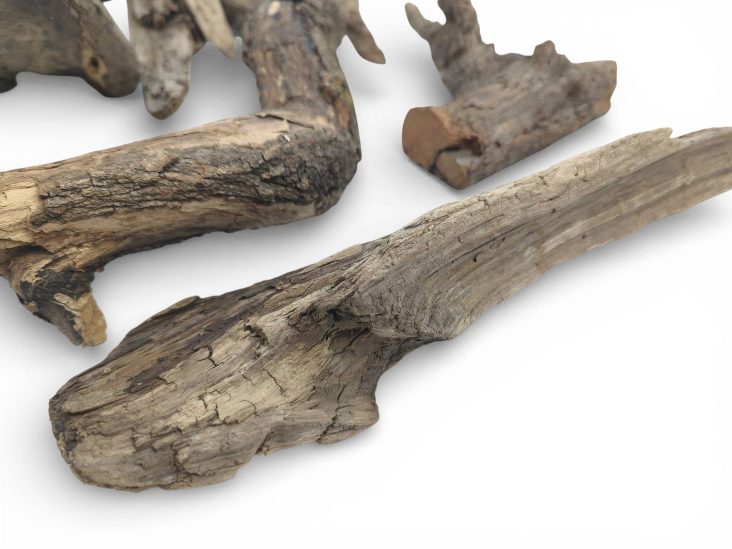Several pieces of rough, unrefined wood with visible cracks and grain against a plain white surface.