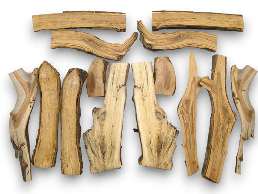 An overhead view of an assortment of halved timber pieces, showcasing varied irregular shapes and natural edges.