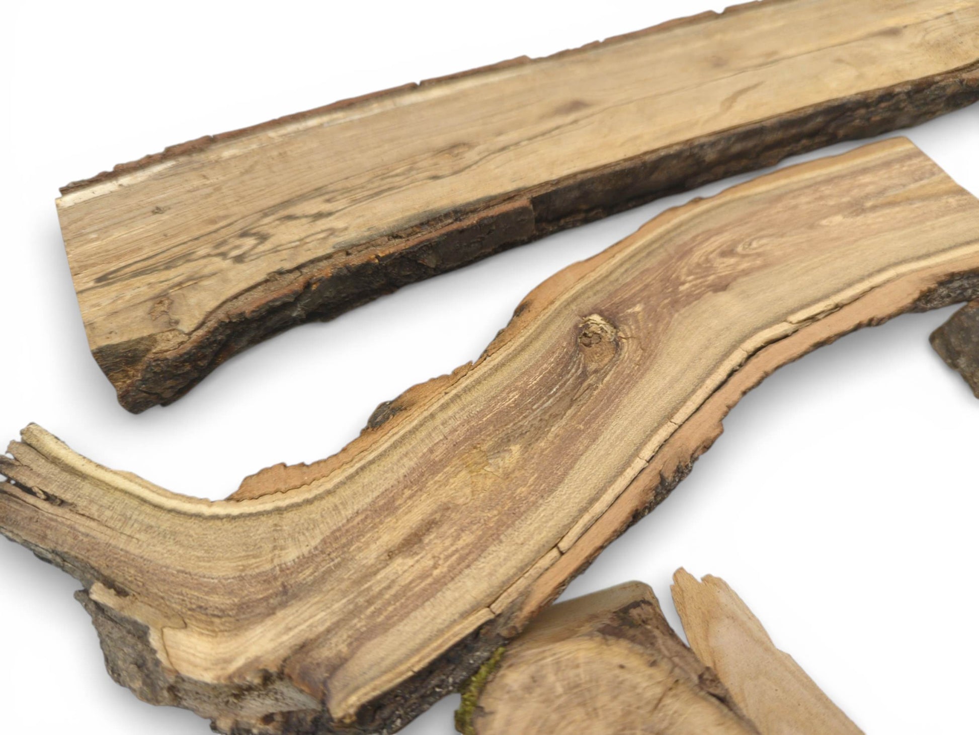 An arrangement of split wood pieces, featuring a curved section with visible grain and growth lines.